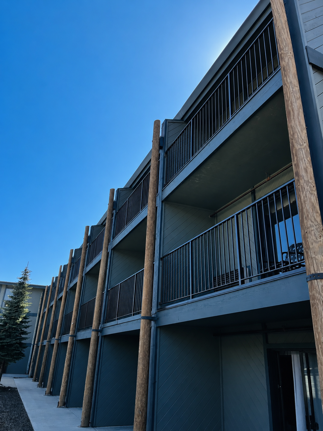 Apartment building balconies with black railings and wood posts
