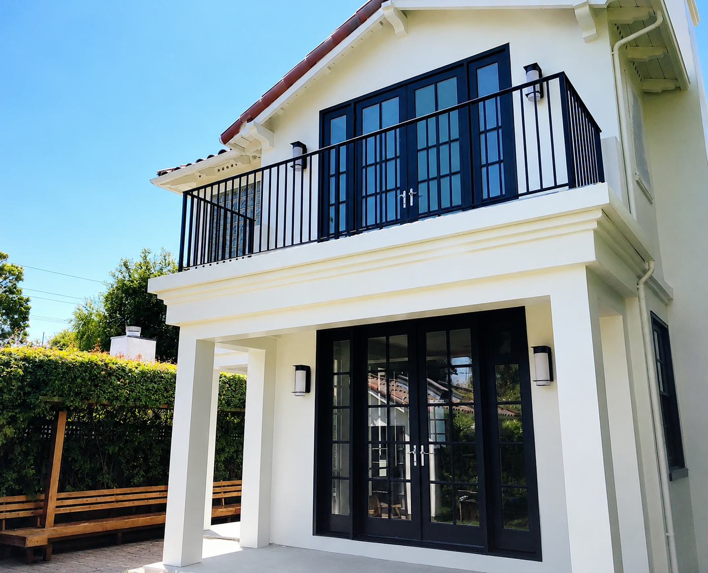 White home balcony with black metal railing and French doors