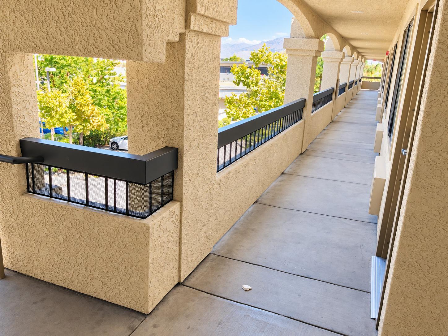 Commercial balcony railing detail beside stucco columns