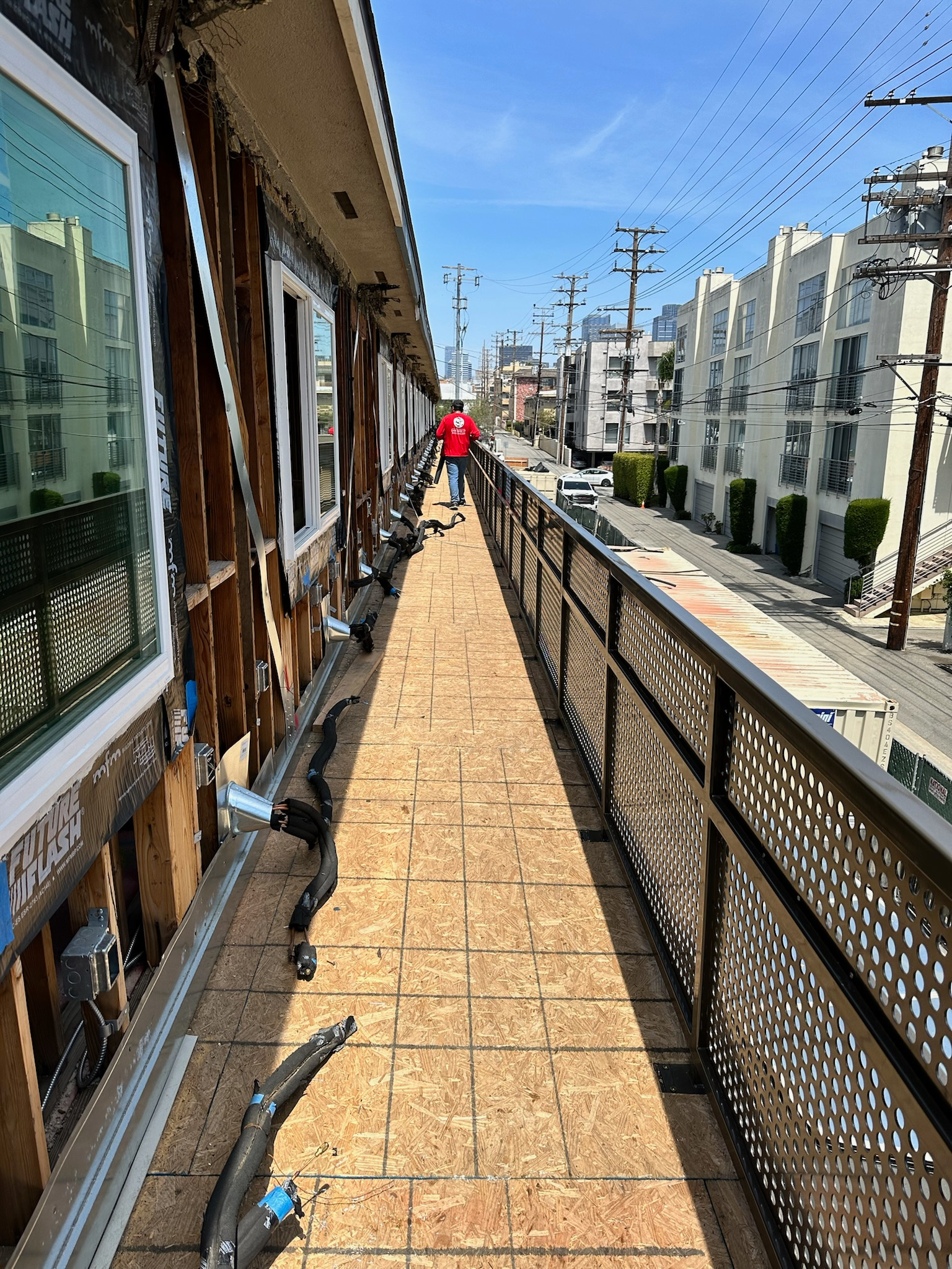 Commercial balcony walkway with perforated metal railing during construction