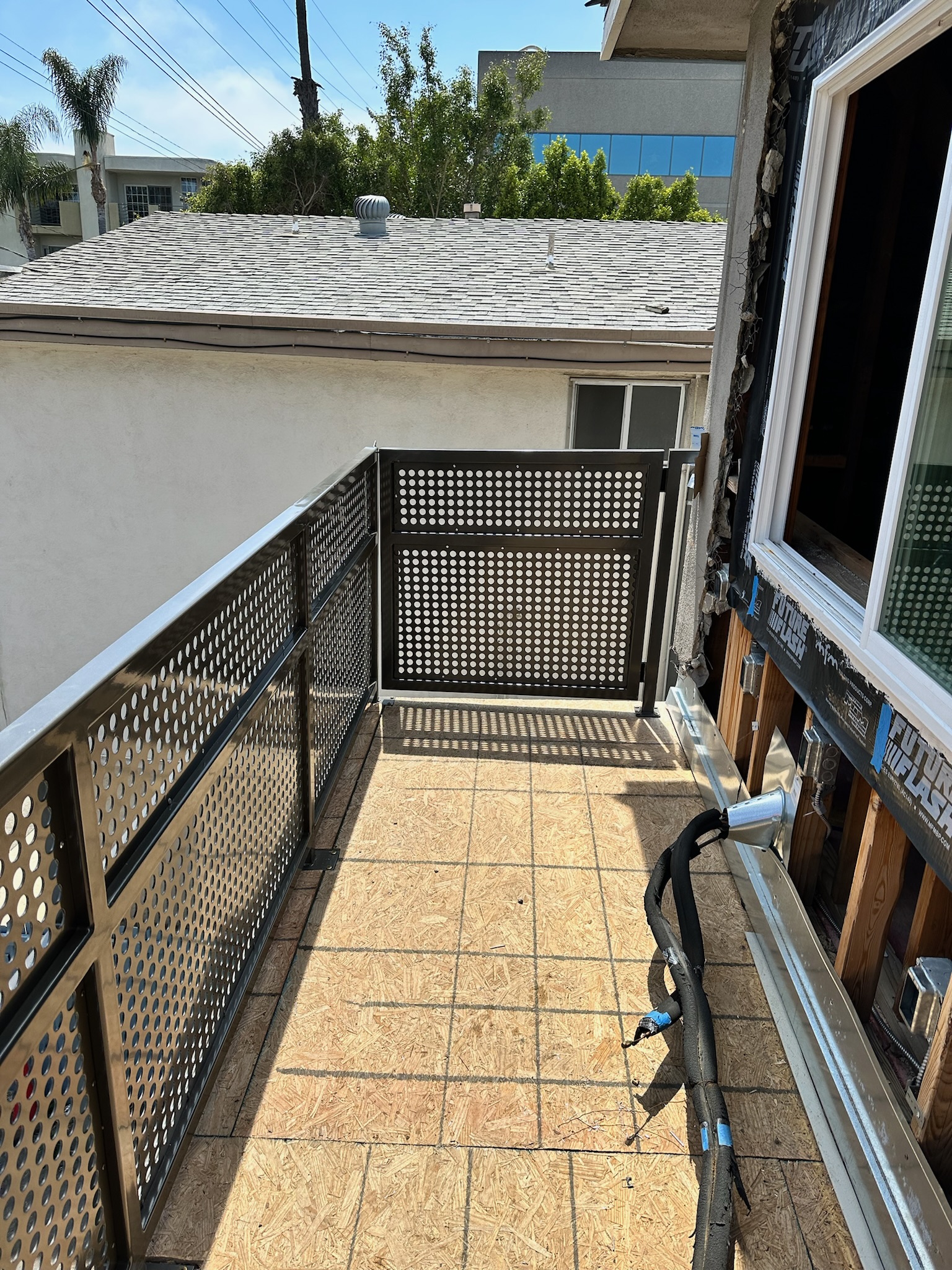 Commercial balcony gate with perforated metal panels during construction