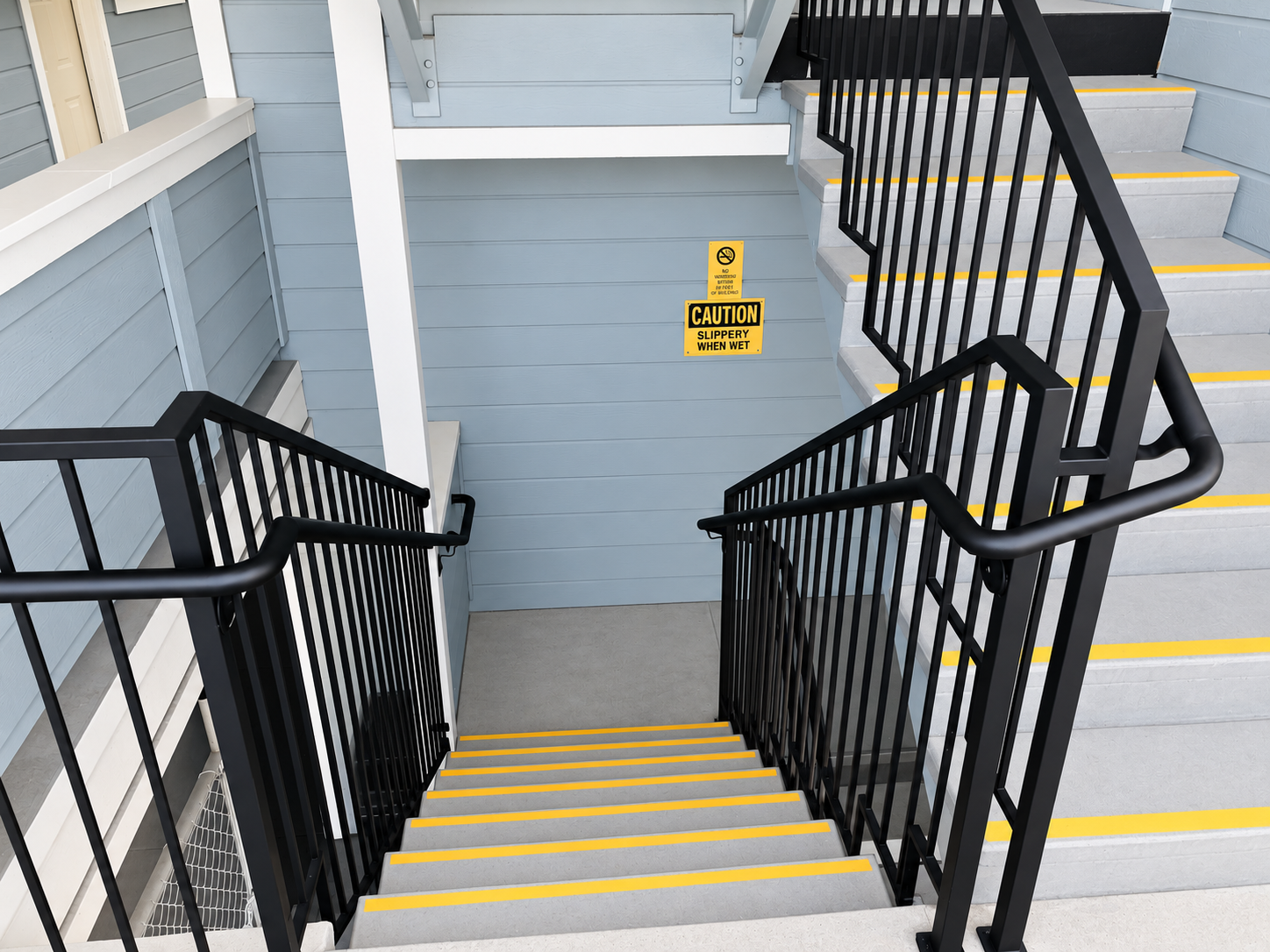Commercial multi-level stair railing with black metal guardrails