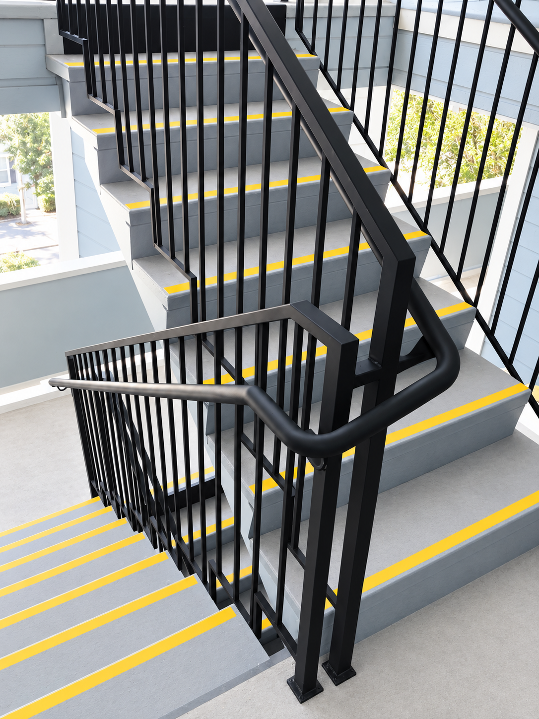 Commercial stair railing closeup with black vertical balusters
