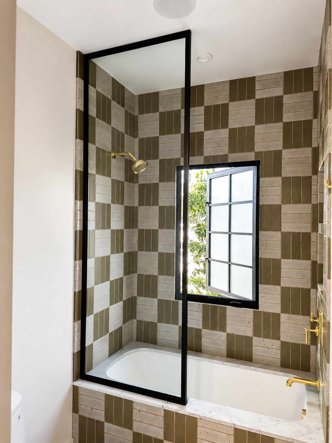 Black metal and glass bath enclosure above tub with patterned tile walls