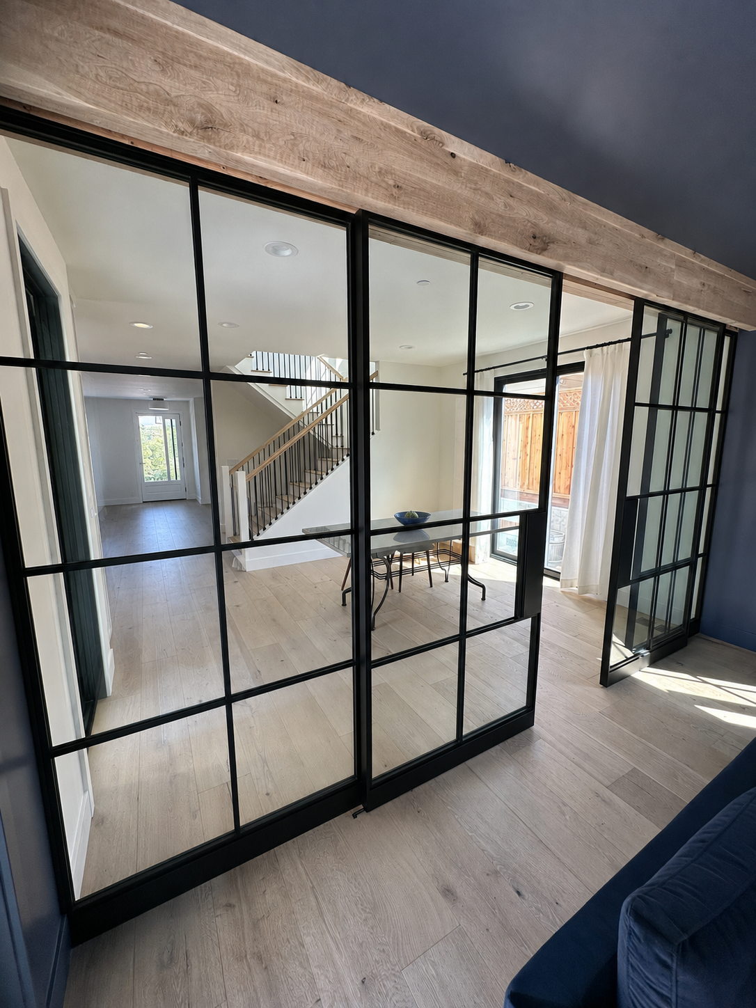 Black interior glass partition doors with wood beam