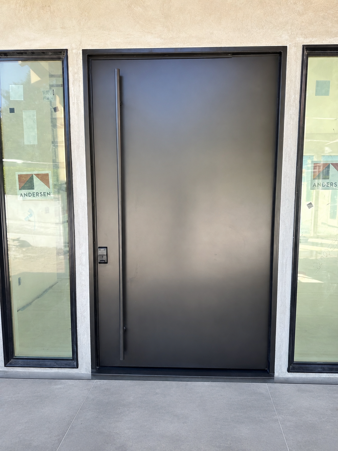 Modern black solid entry door between glass sidelights
