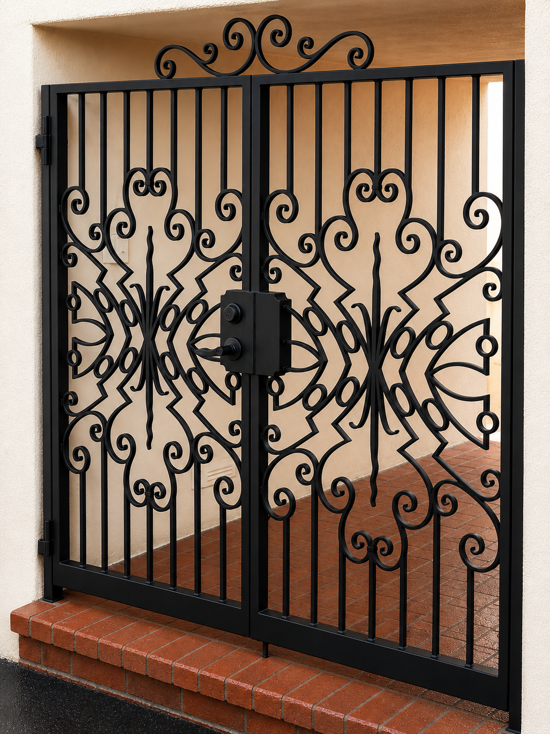 Black ornamental metal entry gate with scrollwork and brick threshold