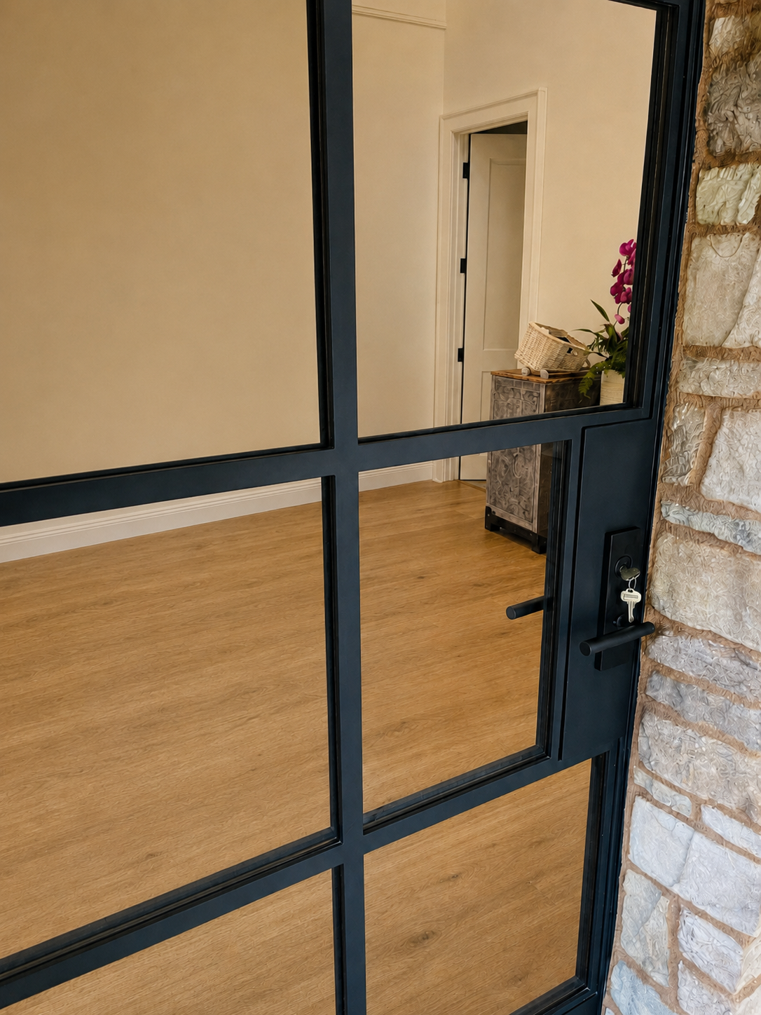 Close detail of black metal glass entry door with lock and handle