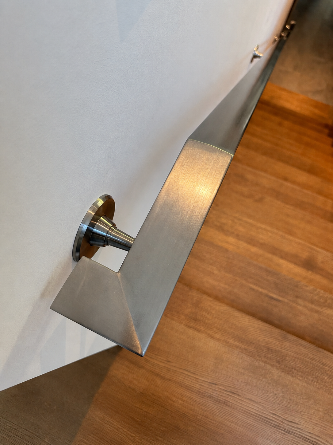 Close detail of stainless steel stair handrail bracket