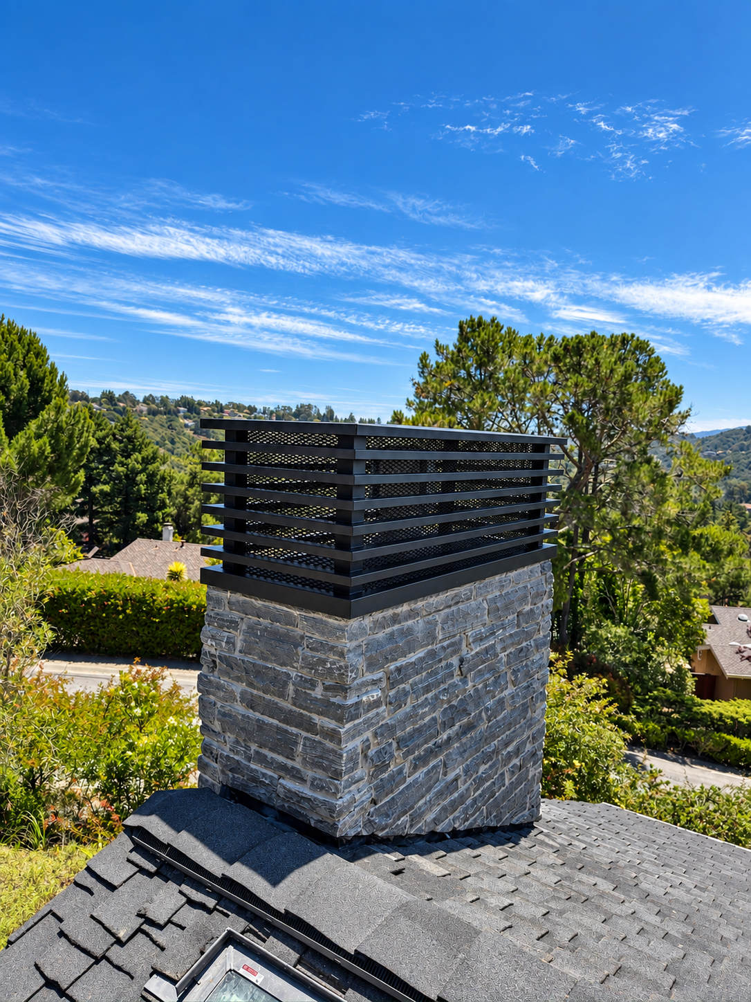 Close view of black horizontal metal chimney cap over a stone chimney