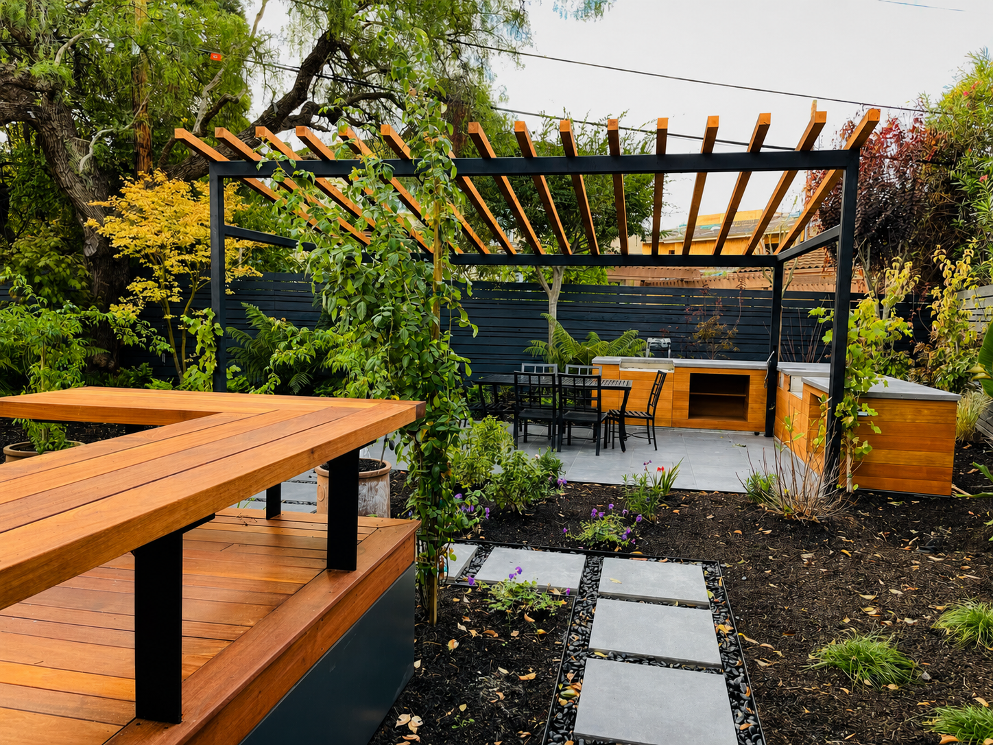 Wood and black metal pergola over garden patio with matching deck details