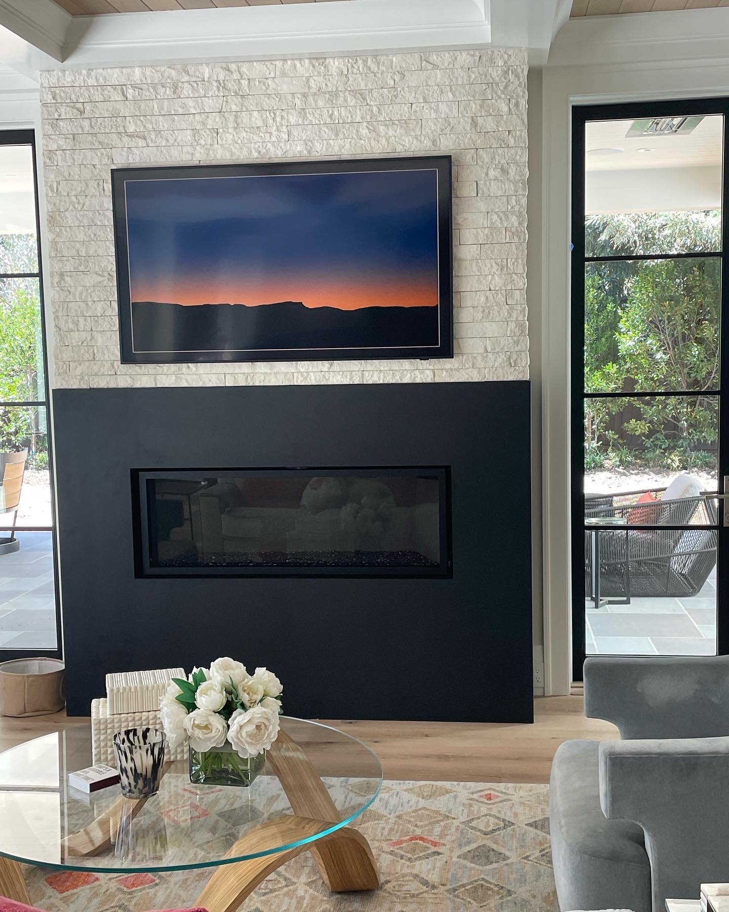 Interior fireplace wall with black metal surround and mounted television