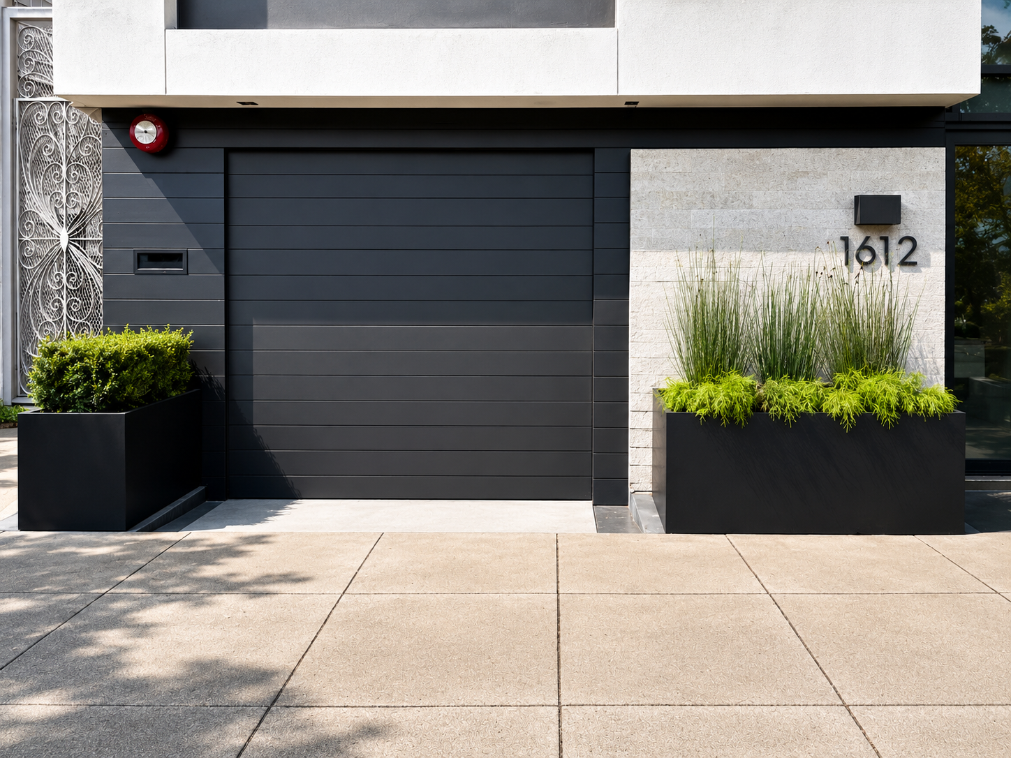 Modern black garage door with matching black metal planters