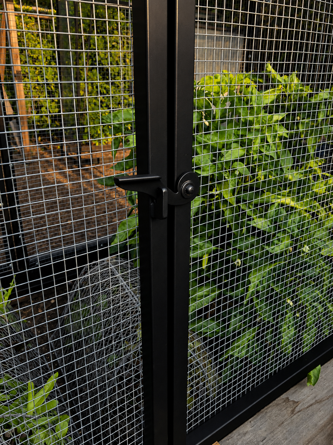 Close detail of black mesh garden enclosure latch
