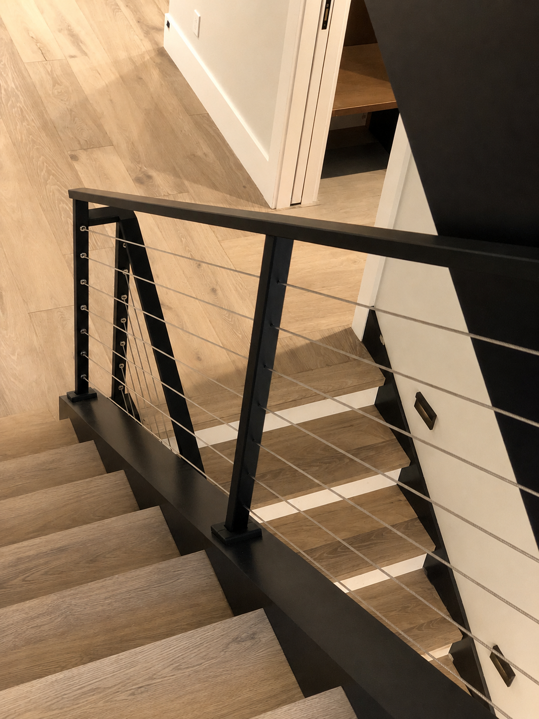 Cable railing detail over wood stair landing
