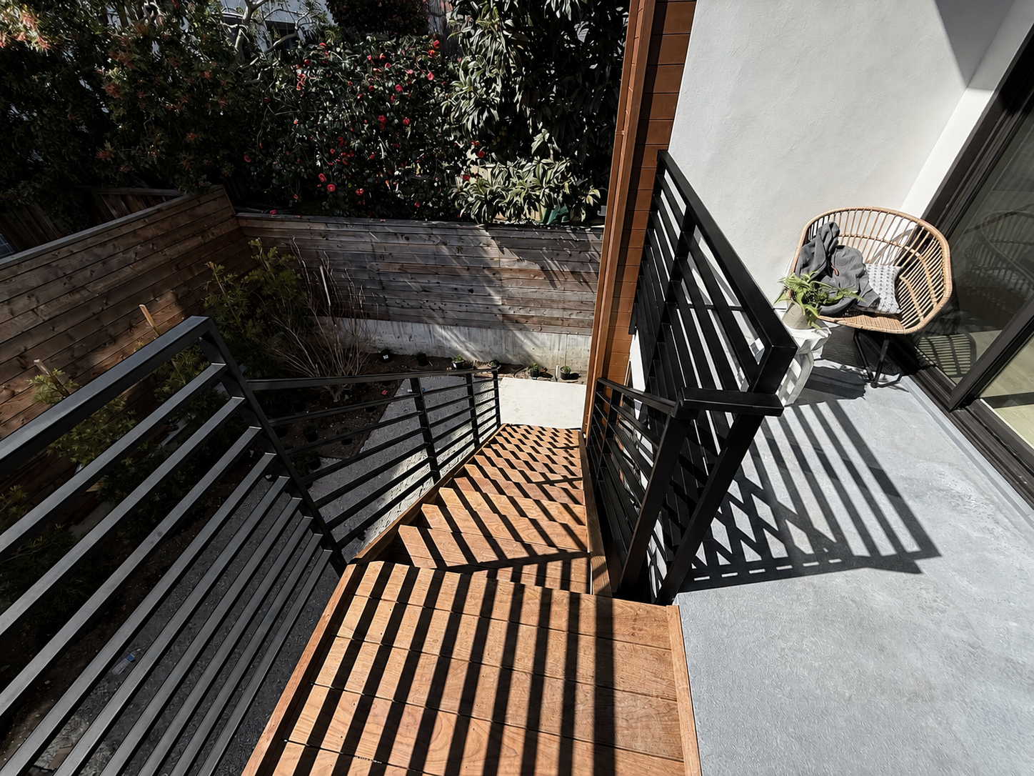 Black railing and stair shadows on outdoor landing