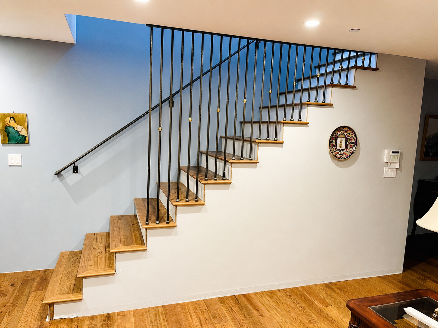 Black stair railing with brass accents and wood steps