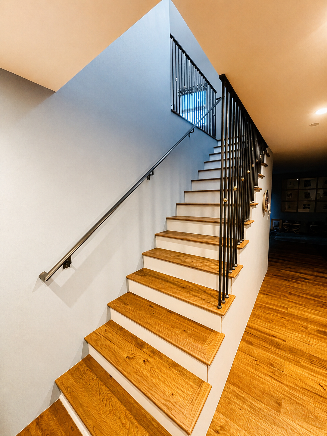 Wood staircase with black railing and brass accent details