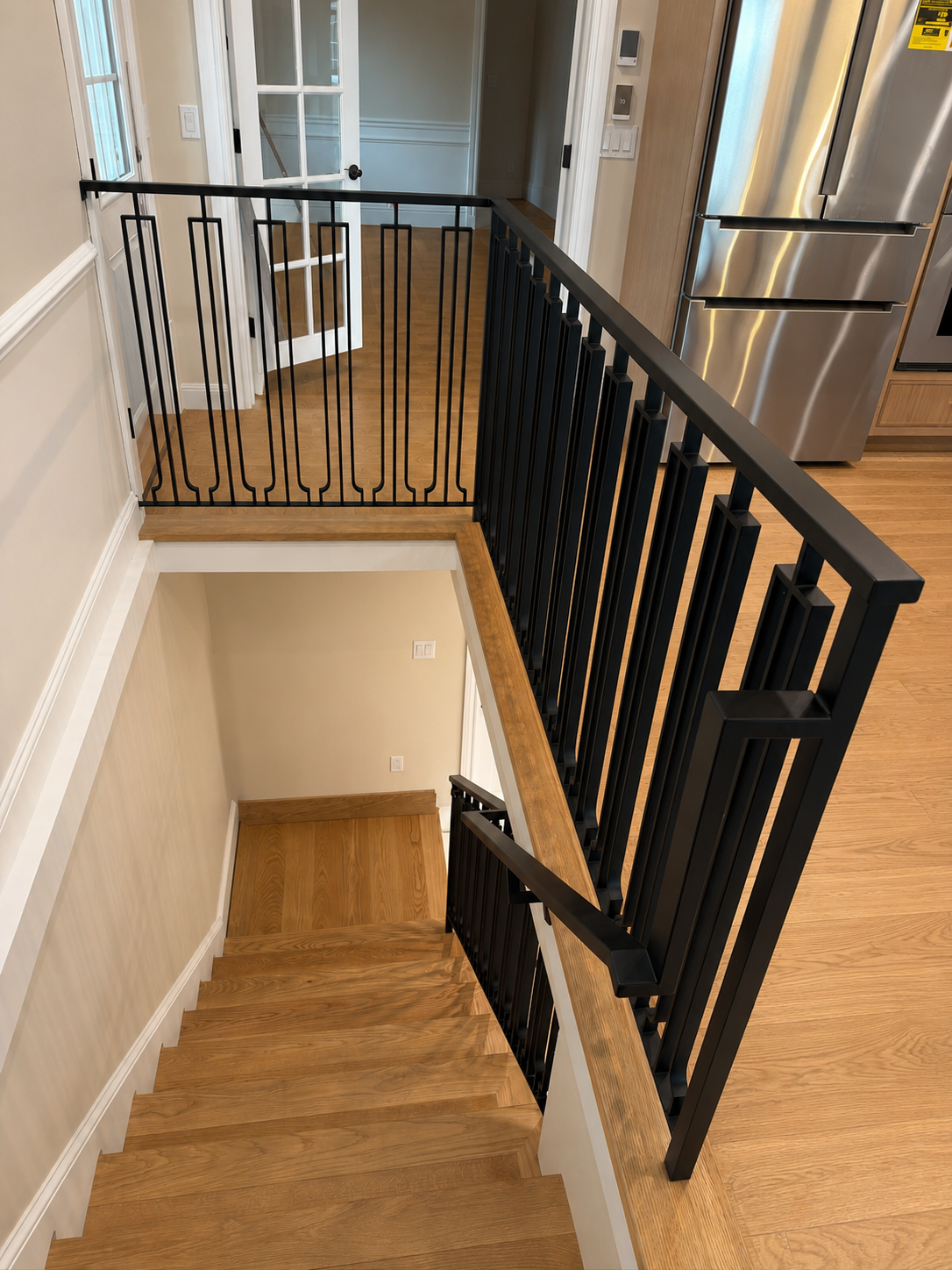 Black interior railing viewed from upper stair landing