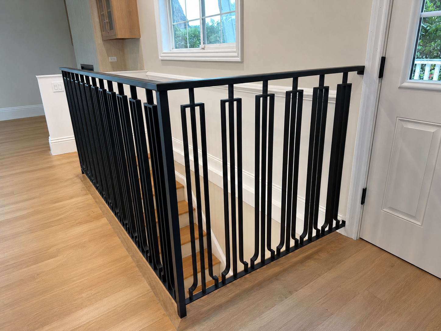 Black railing around stair opening with wood floor