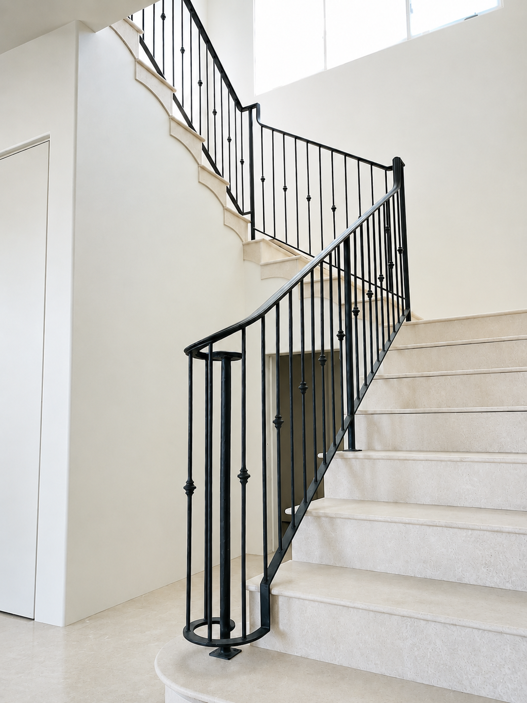 Black metal stair railing on light stone staircase