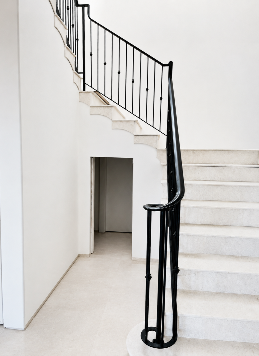 Black handrail and stair railing on light stone stairs