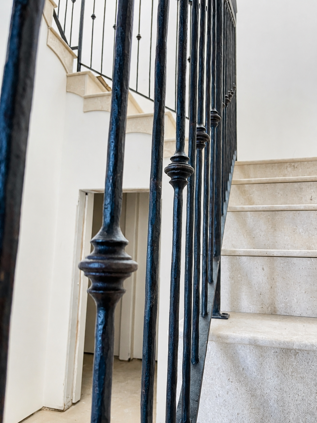 Close detail of black railing balusters on light stone staircase