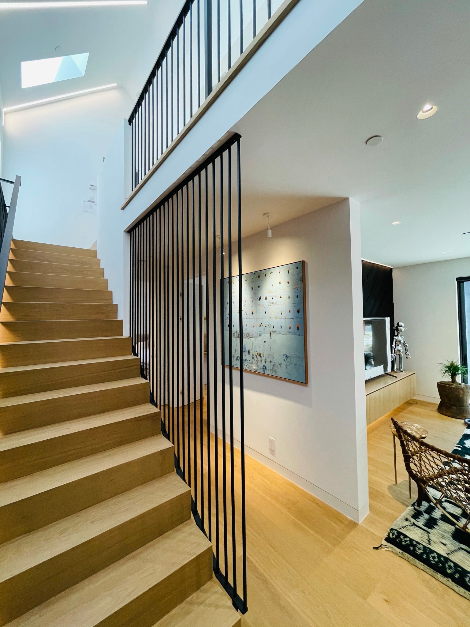 Tall black railing panels along modern wood staircase