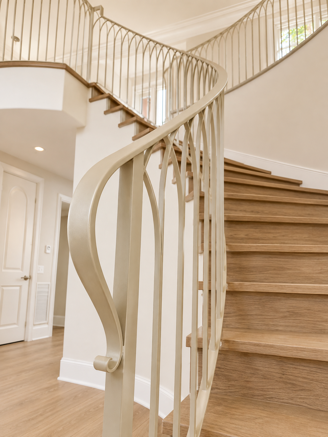 Cream curved railing detail beside wood staircase