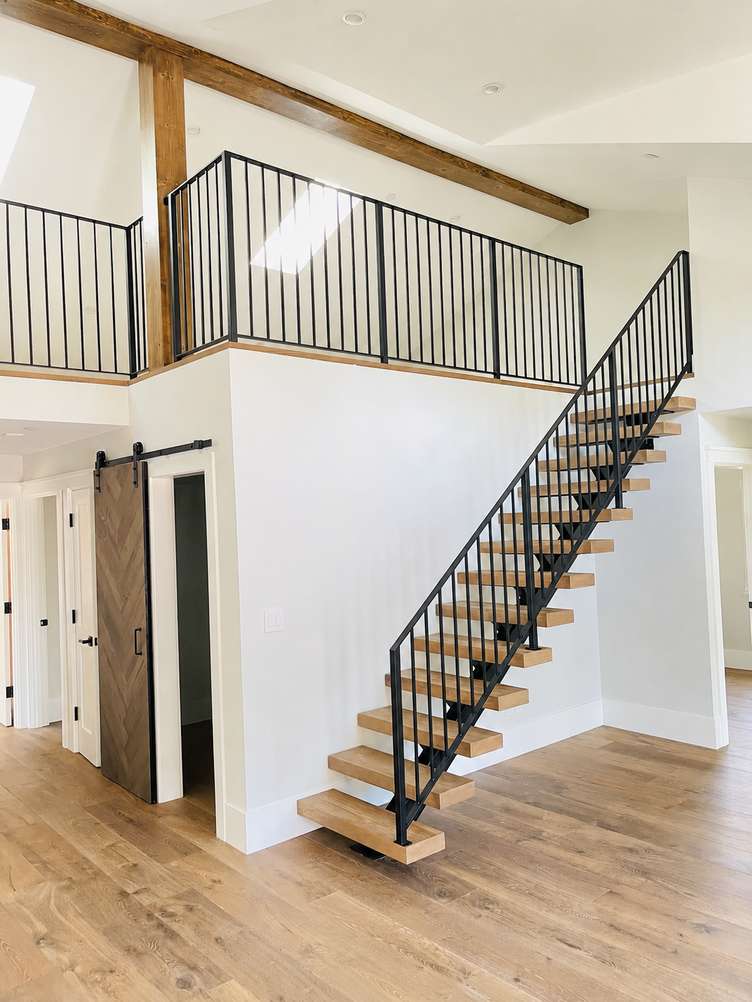 Floating wood stair with black metal railing