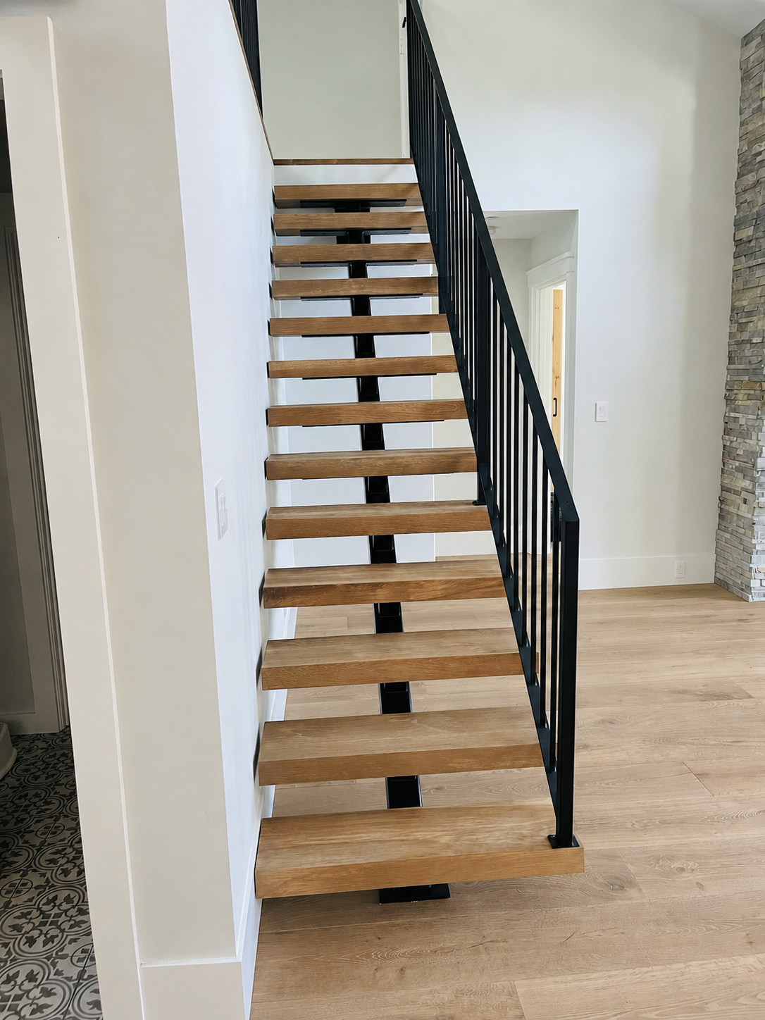 Floating stair with black railing and open risers