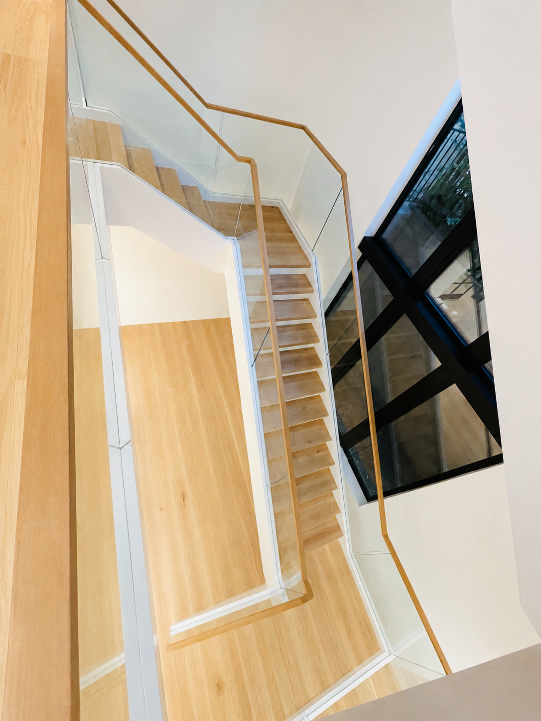 Top view of glass stair railing with brass handrail