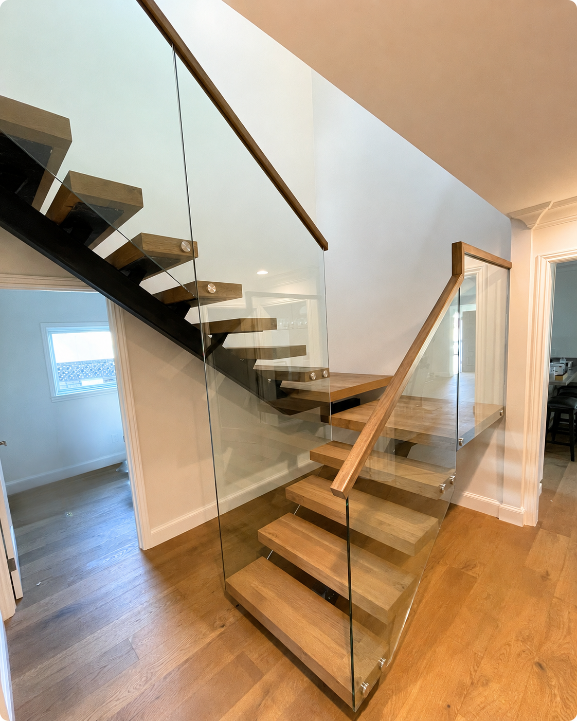 Interior glass stair railing with wood handrail