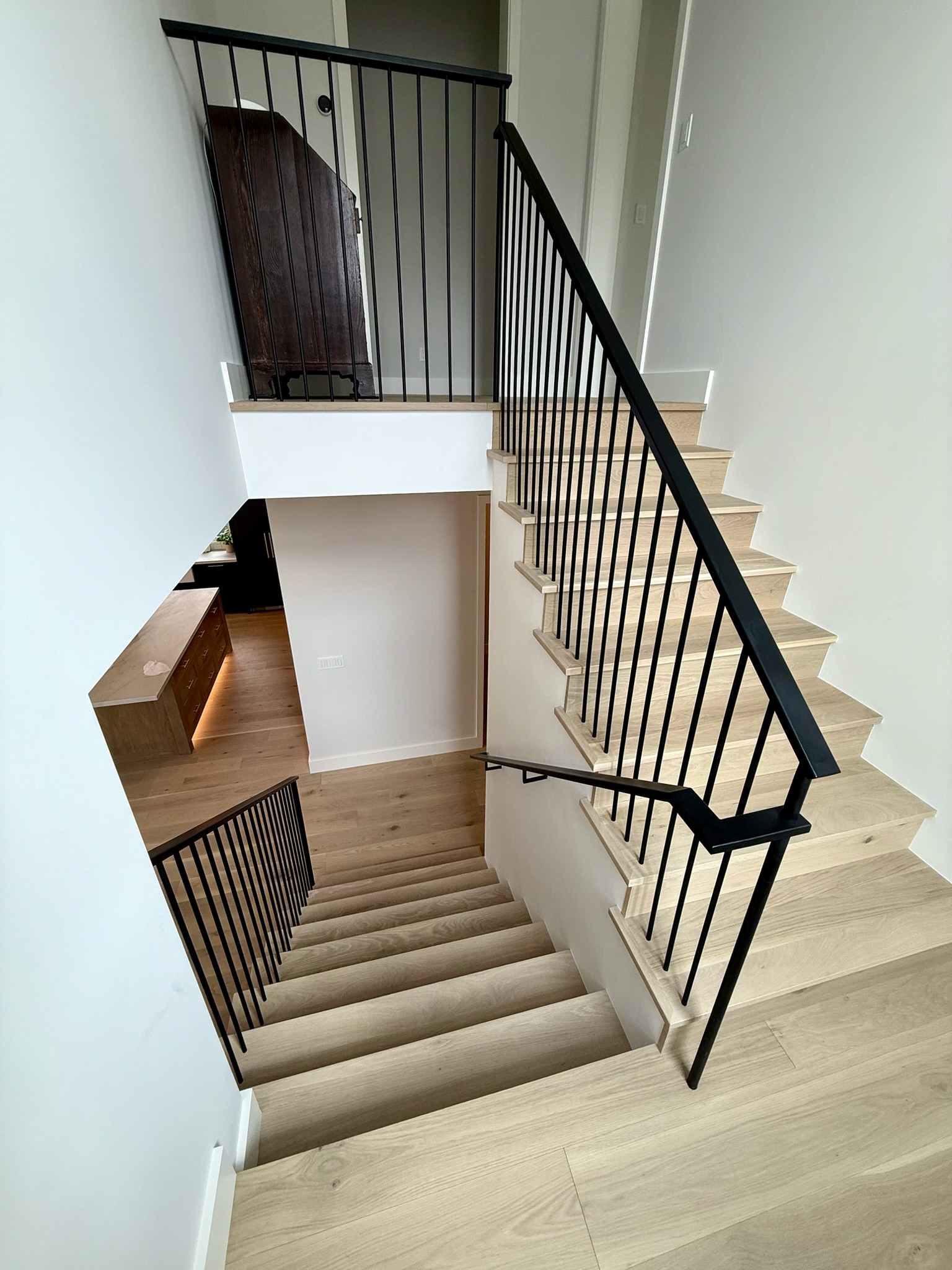 Modern black stair railing with light wood stairs