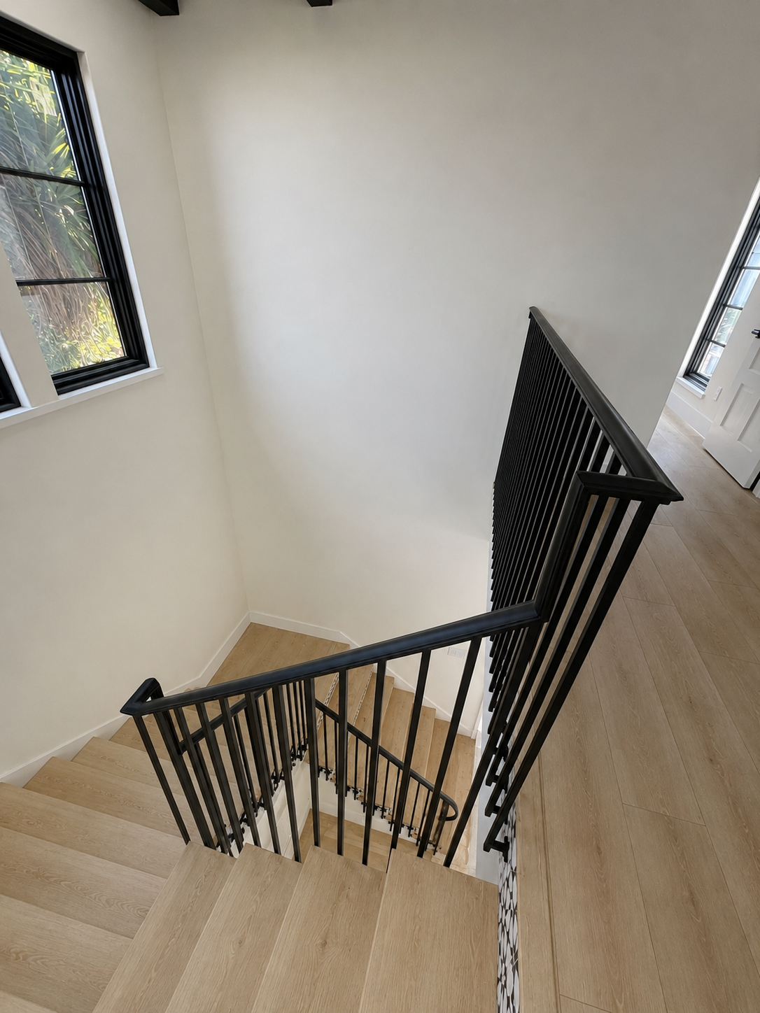 Upper view of black railing around patterned stairwell
