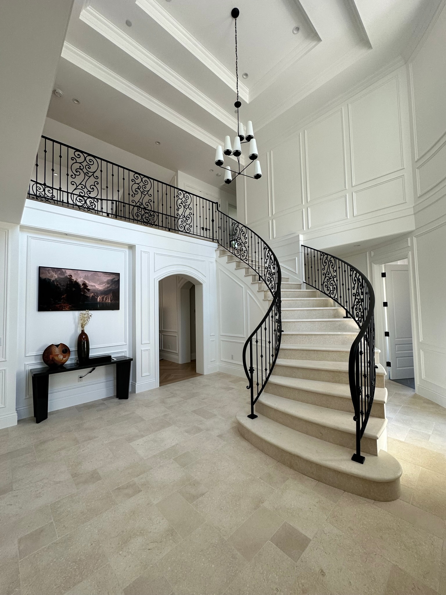 Ornamental curved stair railing in white foyer
