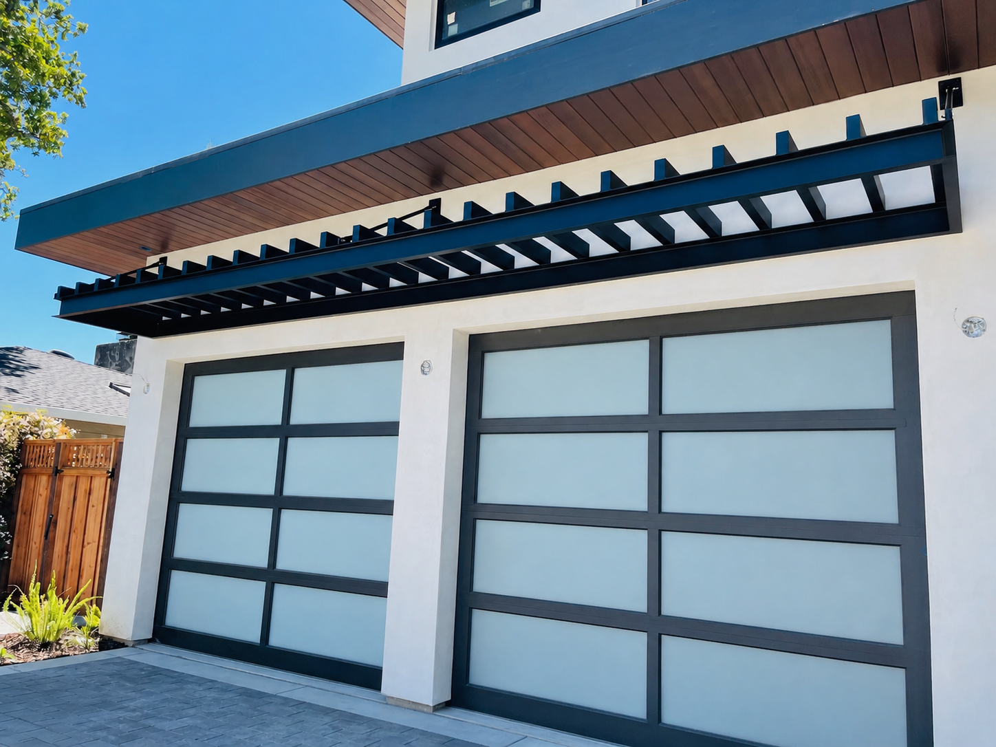 Wide view of black metal trellis above modern garage doors