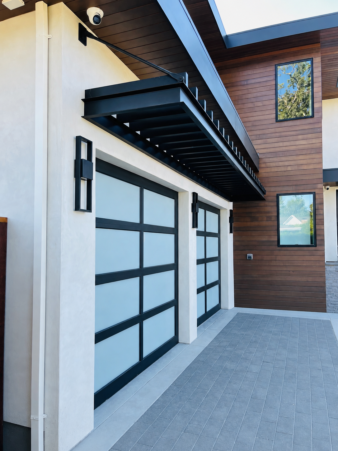 Modern home exterior with black metal trellis and wood siding
