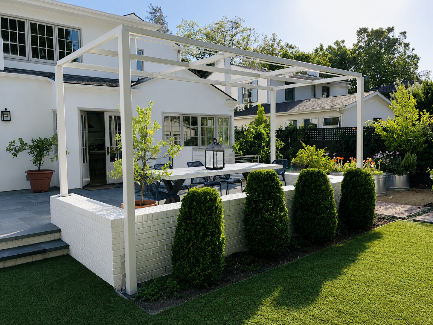 White patio trellis frame over outdoor dining area and garden